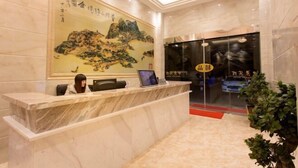 A reception desk with a large painting of mountains and a car parked outside. - Zhoushan Shenjiamen Zhongjing Hotel(Banshengdong Passenger Terminal Branch) (Zhoushan)