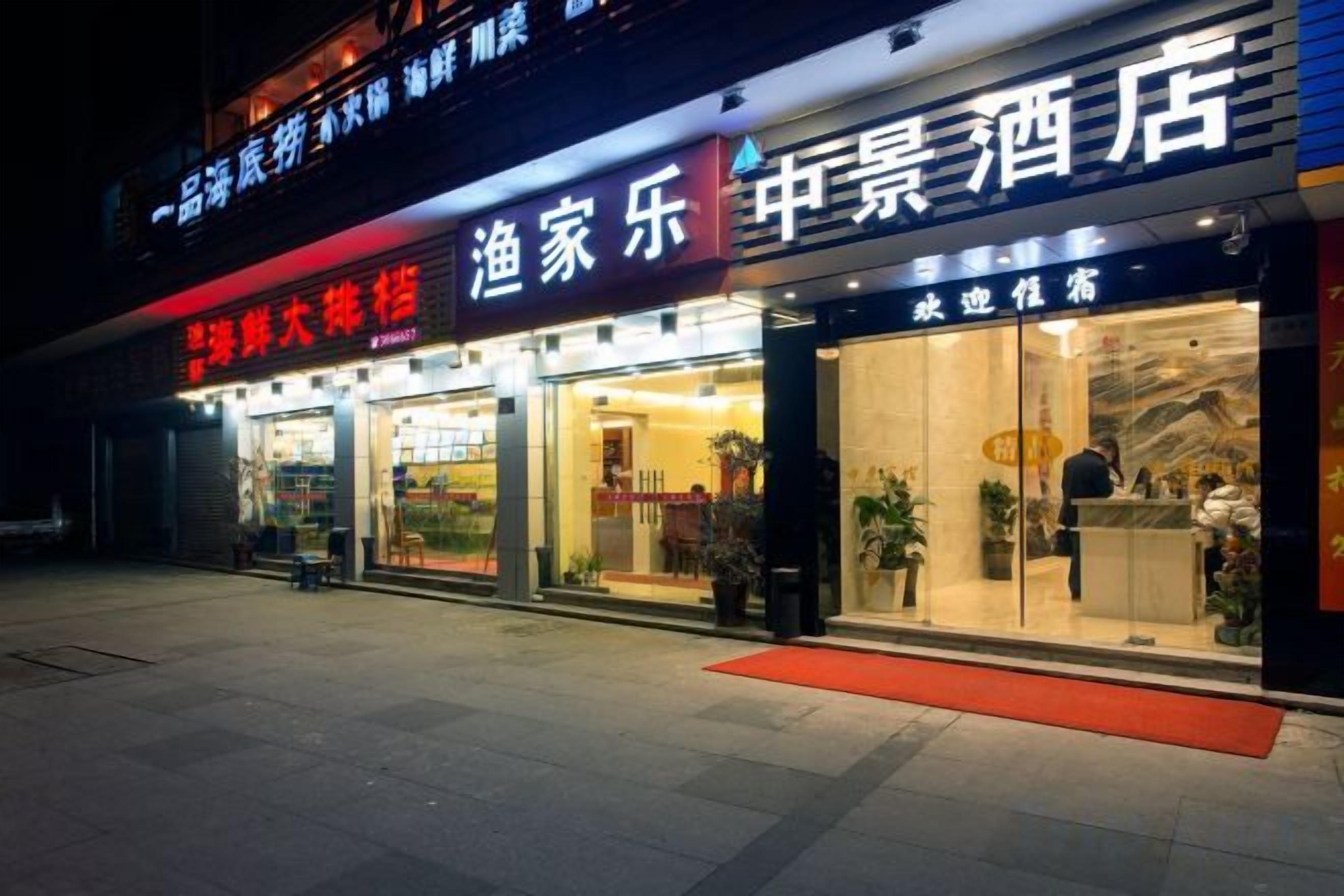 Un hotel con recepción, entrada visible y una alfombra roja que lleva a la puerta.