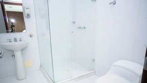 A bathroom with a glass-enclosed shower, a white sink, and a toilet. - 2-bedroom apartment in Bocagrande- Cartagena (Bolívar)