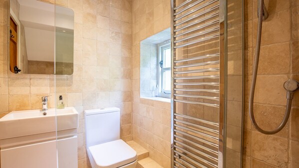 Un baño con lavamanos, inodoro y cabina de ducha de vidrio.