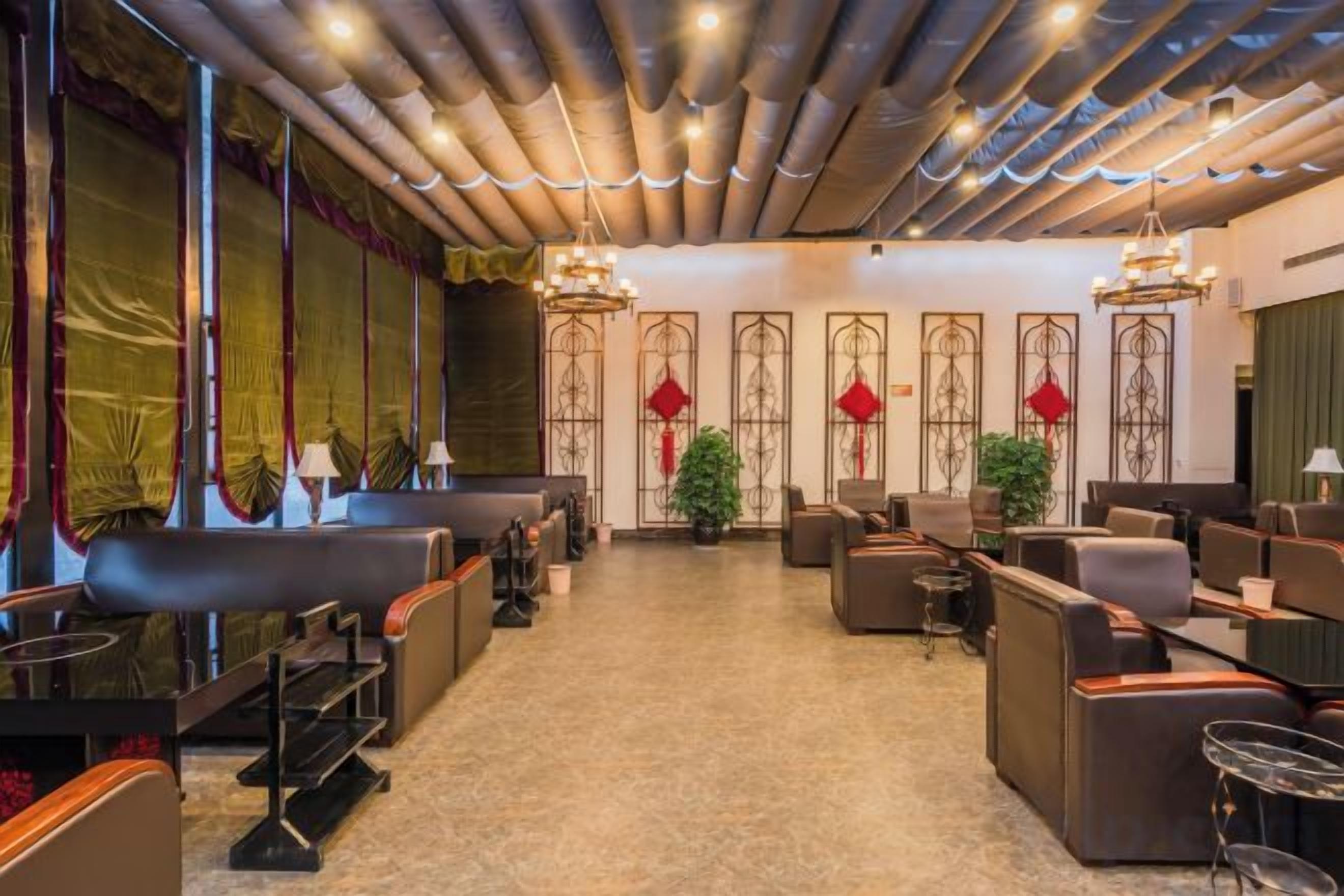 A hotel lobby with seating areas, a reception desk, and decorative elements.