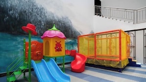 A children's play area with slides and a climbing structure. - Jiuyuan Hotel (Jiuzhaigou)