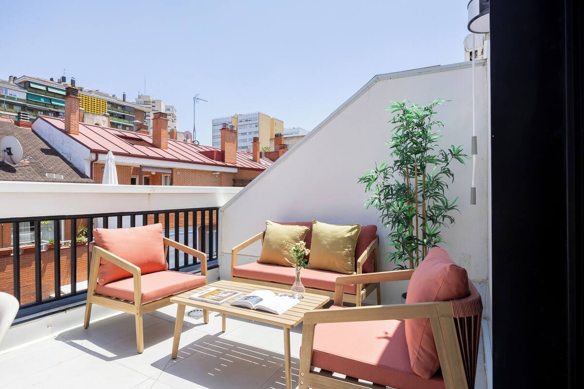 Un balcón con sofá, sillas y una mesa.