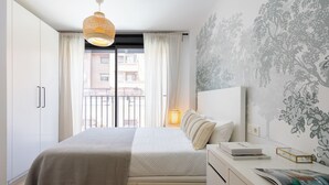 A bedroom with a bed, bedside table, and a window with curtains. - Edmond Vibes Airport - Ifema Hub (Madrid)