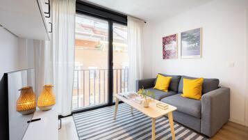 A modern living room with a grey sofa, yellow cushions, a wooden coffee table, and two decorative lamps.