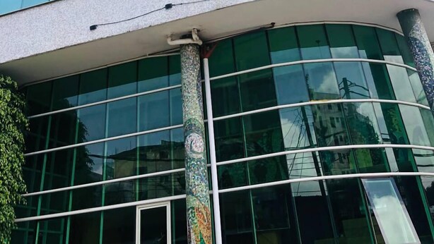 A modern building with curved architecture, large glass windows, and decorative columns. - Shalla Guesthouse and Wellness Center (Addis Ababa)