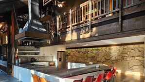 Una cocina moderna con una isla grande, taburetes de bar y una pared decorativa de piedra.