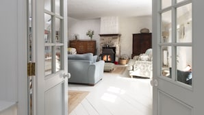 Ein gemütliches Wohnzimmer mit Kamin, Sofa und Esstisch.