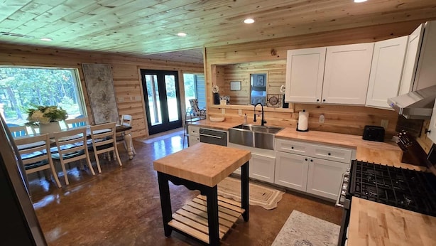 Une cuisine moderne avec des meubles en bois, un îlot central et un coin repas avec des chaises.