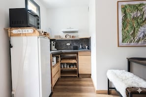 A compact kitchen with a microwave, toaster, and a small refrigerator.