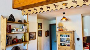 A room with wooden shelves, a cabinet with glass doors, and a ceiling with animal carvings. - Apartment for 4 with with nice view of Briançon (Briançon)