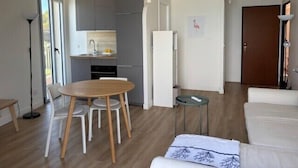 A compact living space with a dining area, kitchenette, and a sofa. - Beautiful 41 m² with balcony (Antibes)