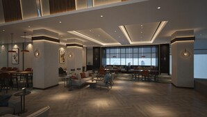 A spacious lobby with a high ceiling, modern furniture, and large windows providing natural light. - Four Points By Sheraton Bekasi (Bekasi)