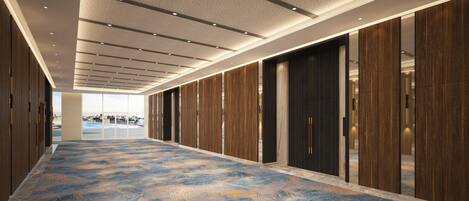 A long corridor with wooden paneling and a patterned carpet, leading to a large glass door at the end.
