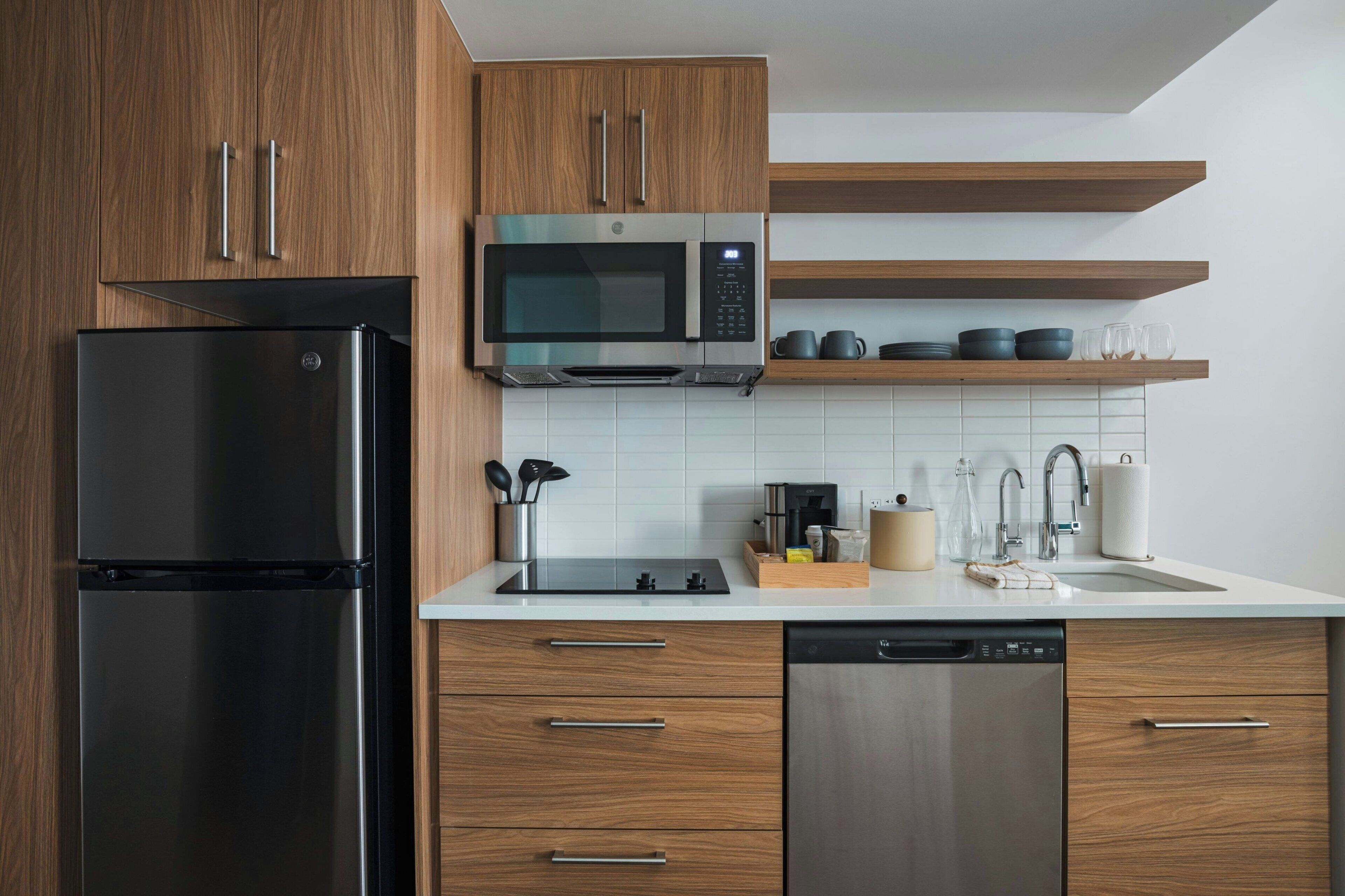 A modern kitchen with wooden cabinets, stainless steel appliances, and a white countertop.