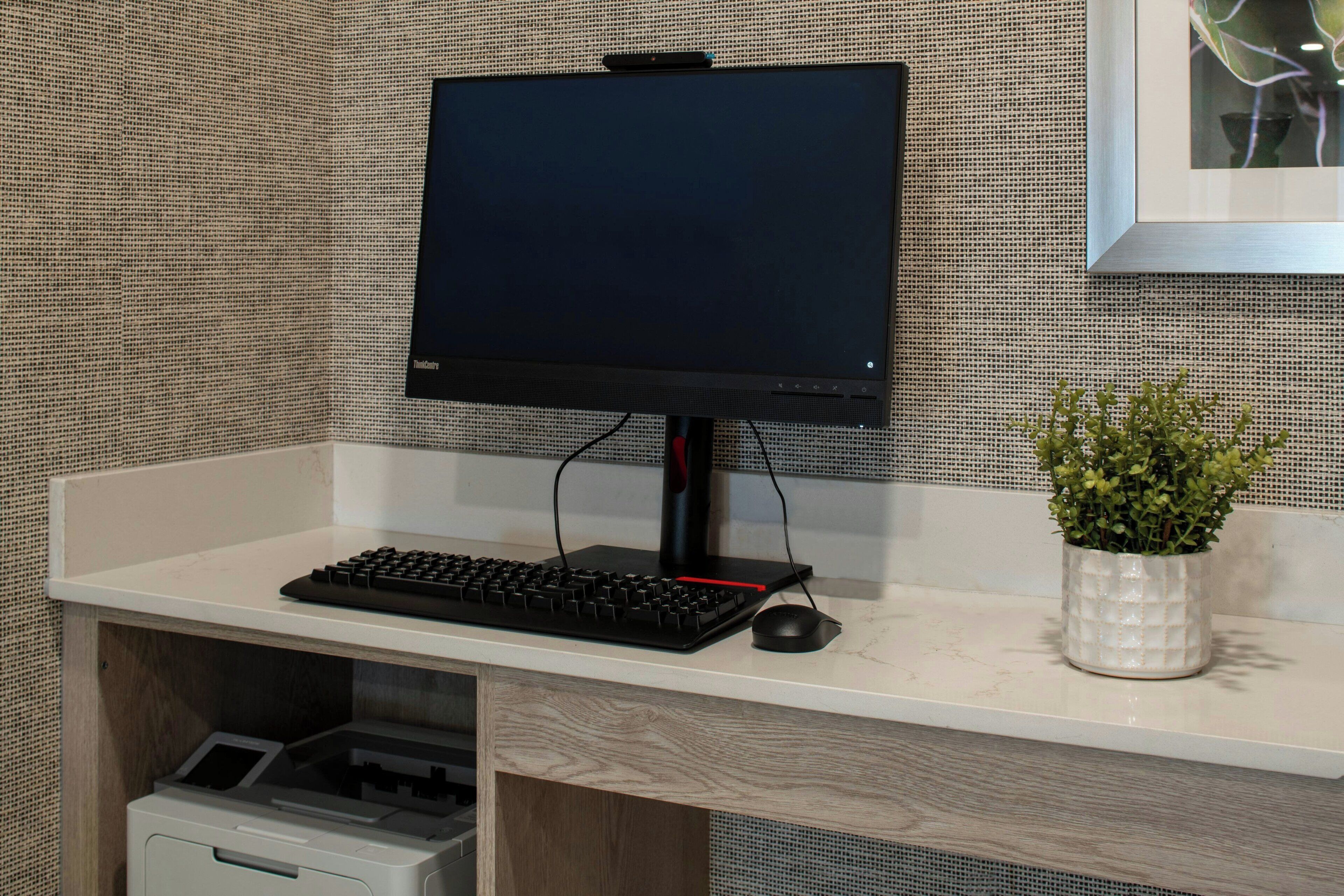 Un escritorio con un monitor, teclado y ratón.