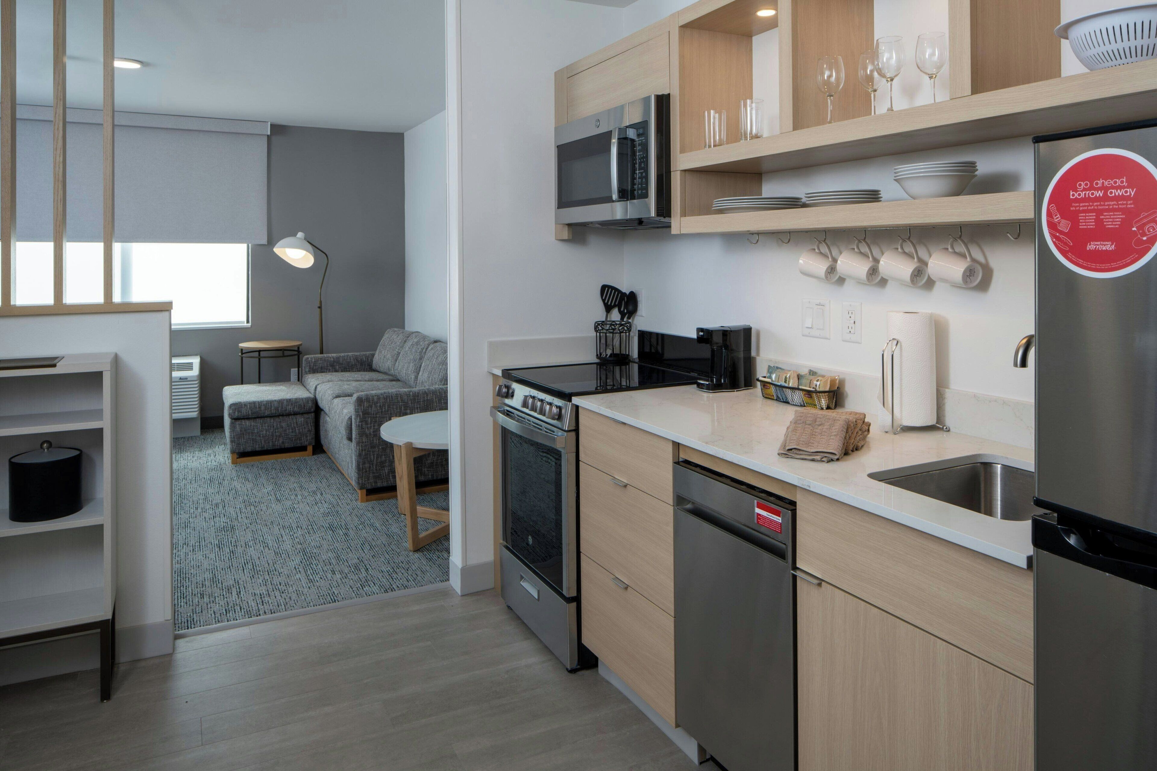 A modern kitchen with a microwave, stove, and dishwasher. There is a dining area with a table and chairs.