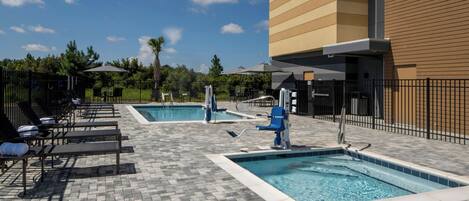 A pool area with multiple pools, lounge chairs, and umbrellas.