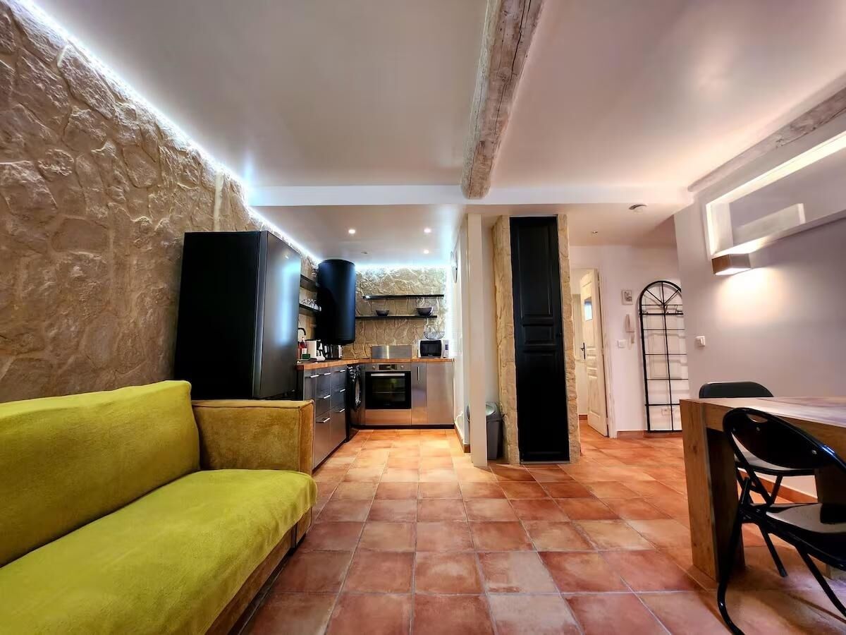 A compact living space with a kitchen area, a dining table, and a sofa.