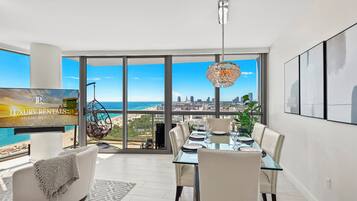 A spacious dining area with a city view, a hanging chair, and a large window.