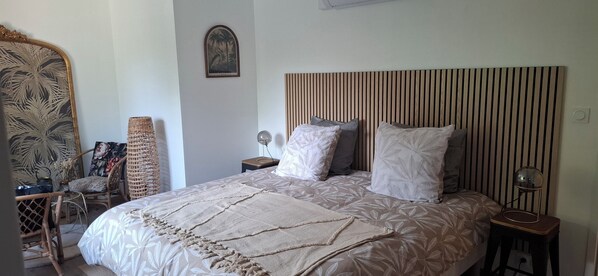 A bedroom with a bed, a nightstand, a lamp, a chair, and a wall-mounted picture. - Suite 4 pers 2 bdrms 2 bathrms - Baie Mont St Michel (Le Val-Saint-Père)