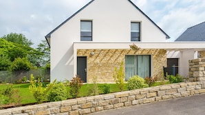 A modern two-story house with a stone facade, a sloped roof, and a well-maintained garden. - Ti Armor - Maison à 200m de la plage (Benodet)