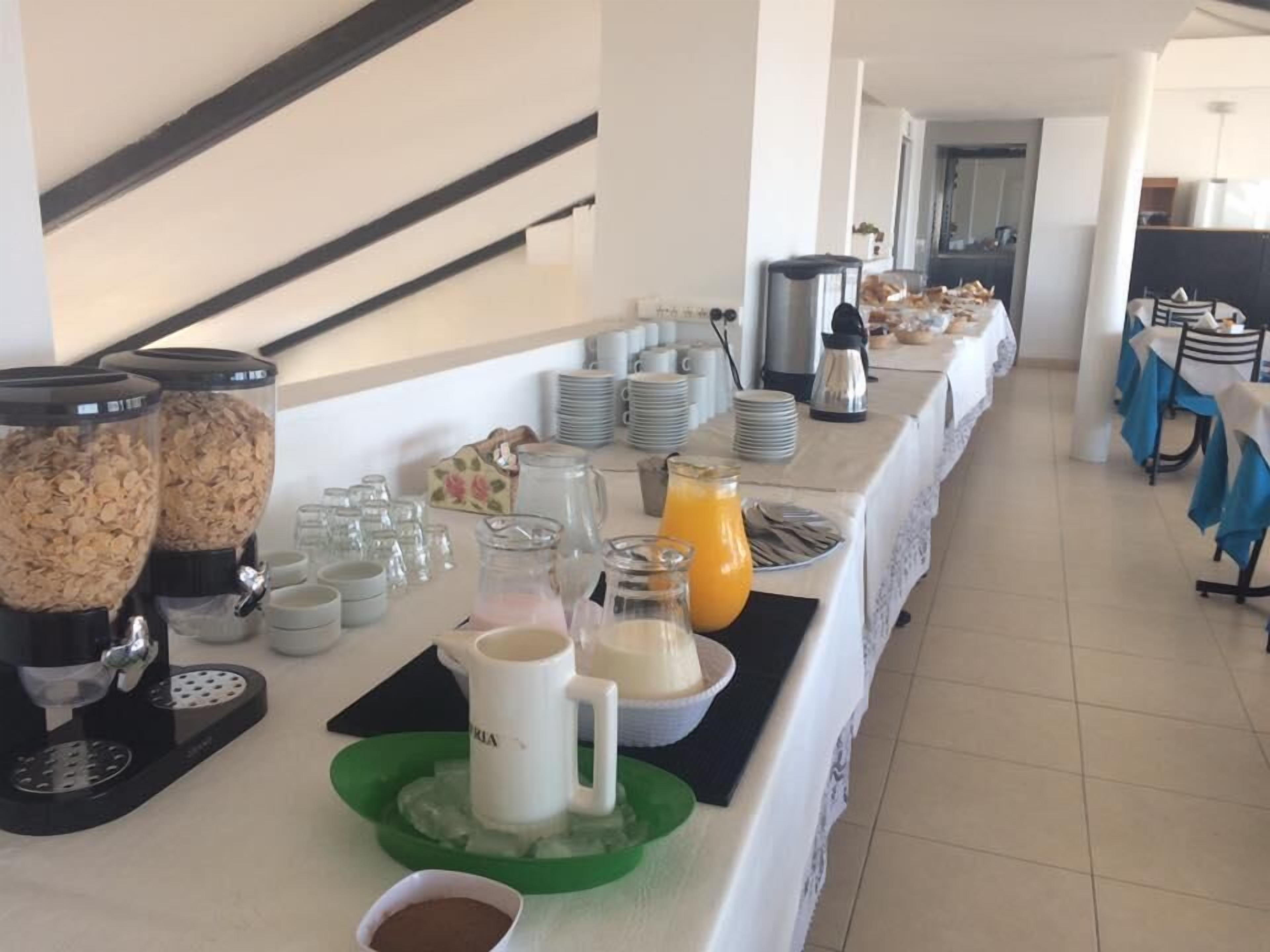Una mesa de desayuno buffet con diversos alimentos y bebidas.