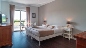 A bedroom with a bed, bedside tables, a desk, and a television. - Ti Ar Mor Braz- Maison avec grand jardin (Saint-Philibert)