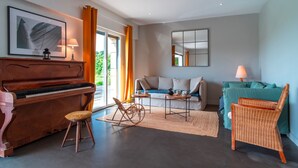 A living room with a piano, a sofa, a rocking chair, and a dining table. - Ti Ar Mor Braz- Maison avec grand jardin (Saint-Philibert)