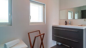 A modern bathroom with a white toilet, a wooden chair, a large mirror, and a grey vanity with drawers. - Ti Ar Mor Braz- Maison avec grand jardin (Saint-Philibert)