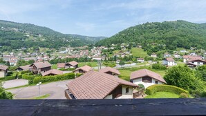 A residential area with houses on a hillside, surrounded by greenery. - Chalet des cimes - Avec jardin (La Bresse)