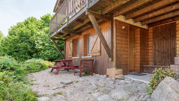 A rustic wooden cabin with a balcony, a gravel driveway, and a picnic table. - Chalet des cimes - Avec jardin (La Bresse)