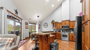 Une cuisine moderne avec des meubles en bois, des appareils en acier inoxydable et un grand îlot central.