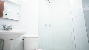 A bathroom with a white sink, toilet, and a glass shower enclosure. -  2-bedroom apartment in Bocagrande- Cartagena (Bolívar)