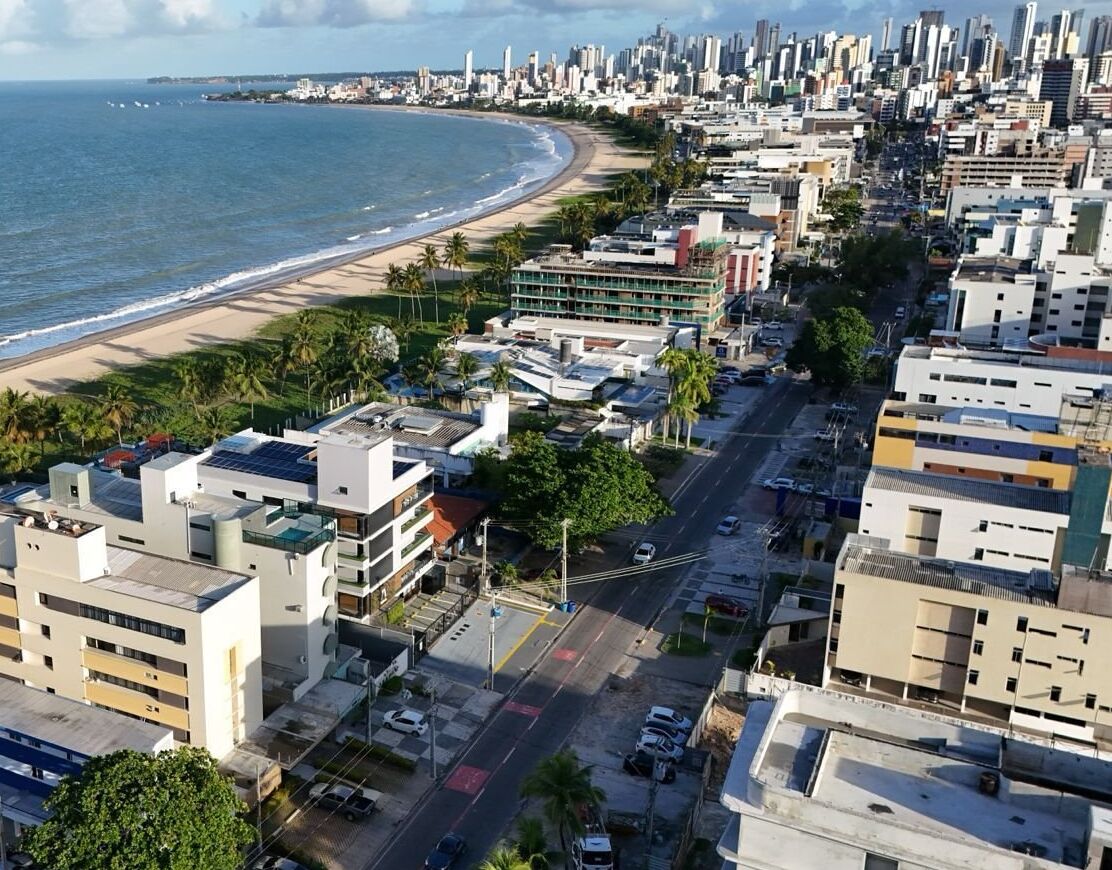 Un paysage urbain côtier avec une plage, des bâtiments et une route.