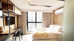 A modern hotel room with a bed, a desk, and a wardrobe. - Get By Side (Joao Pessoa)