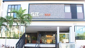 Um edifício moderno com uma placa que diz "GET BY SIDE".