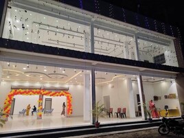 Un hotel con recepción, zona de espera con sillas y balcón con luces de cuerda.