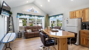 Een moderne keuken met houten kastjes, een bar en een eetruimte met een groot kookeiland.