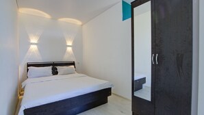 A bedroom with a bed, bedside lamps, a wardrobe, and a mirror. - Chastnyy Sektor (Bosteri)