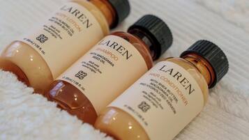 Three bottles of Laren body lotion on a white towel.
