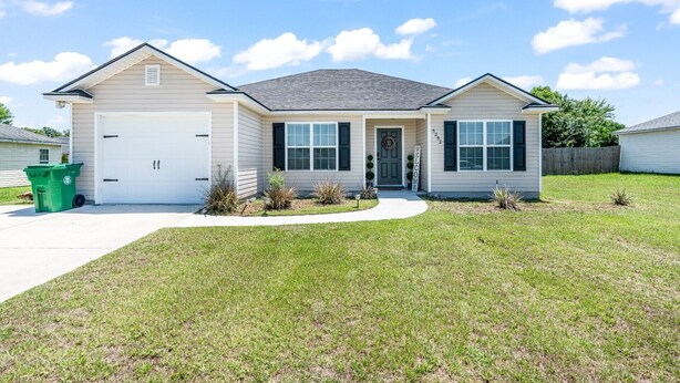 A single-story house with a garage, a front porch, and a well-maintained lawn.