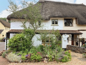 A traditional thatched-roof house with a garden in front. - 1 Myrtle Cottages (Newton Abbot)
