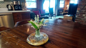 A wooden dining table with a vase of flowers.