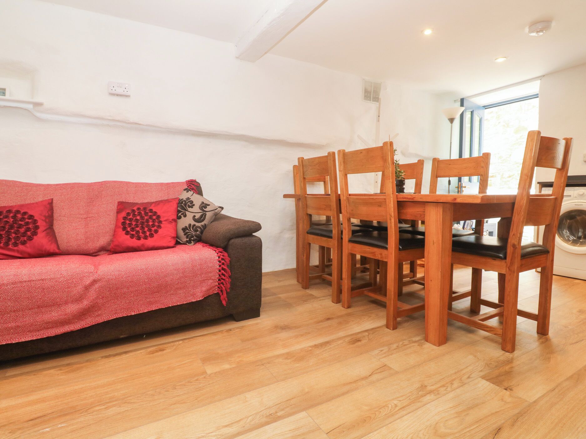 A cozy living area with a sofa and wooden dining table.