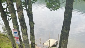 Une zone au bord du lac, avec une jetée en bois, des panneaux d’avertissement et une table de pique-nique.