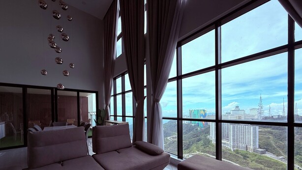A modern living room with a large window, a sofa, and a coffee table.