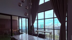 A modern conference room with a large marble table, comfortable chairs, and large windows offering a city view.