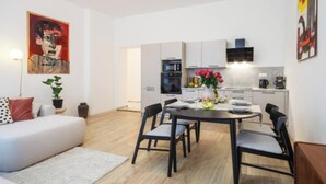 Un appartement moderne comprenant un coin repas, une cuisine et un salon.