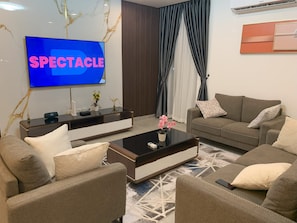 Familie appartement | Woonruimte | Een 65-inch smart-tv met satellietzenders